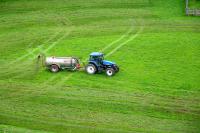 Tractor spreads fertilizer on a field