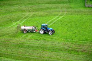 Tractor spreads fertilizer on a field